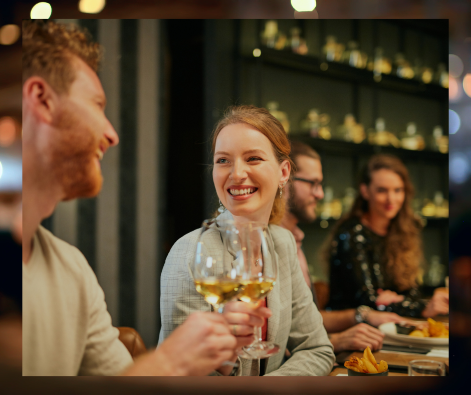 Group dining with glasses of wine.